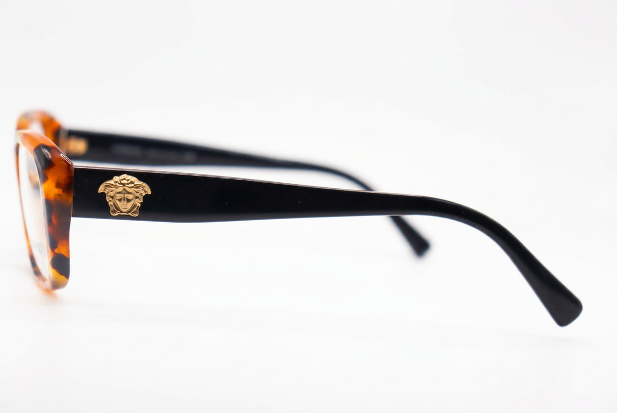 Tortoiseshell eyeglasses with black temples, side view on white background